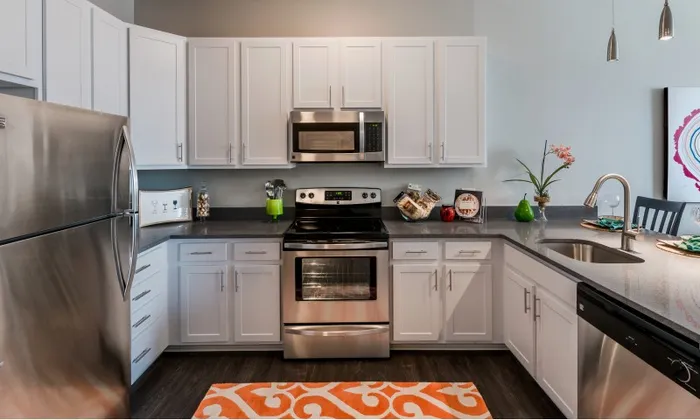 Model kitchen at our apartments for rent in Washington DC, featuring stainless steel appliances and white cabinetry.