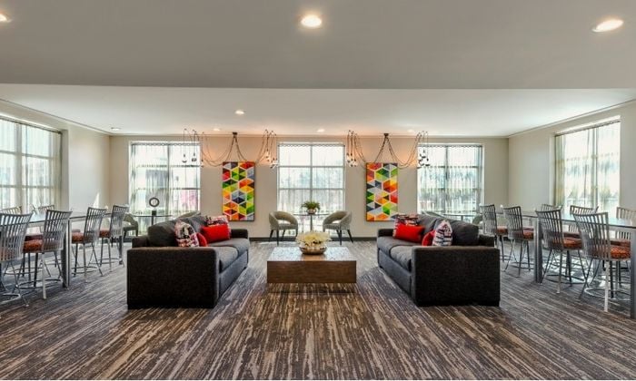 Resident lounge at our apartments for rent in Washington, DC, featuring couches, counter seating, and a coffee table.