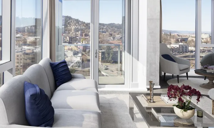 Model living room at our apartments in Portland, OR, featuring cushioned couches and floor to ceiling windows.