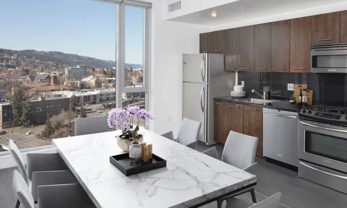 Model kitchen at our apartments in Portland, OR, featuring stainless steel appliances and wood laminate cupboards.