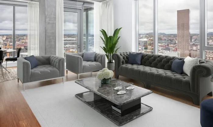 Penthouse Model living room at our apartments in Portland, OR, featuring cushioned couches and floor to ceiling windows.