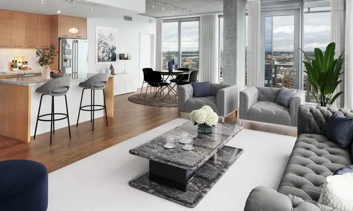 Penthouse model living, dining and kitchen area featuring cushioned furniture.