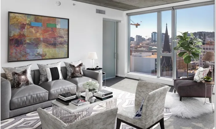 A sleek, monochromatic furnished living room in a Portland Oregon apartment overlooking downtown.