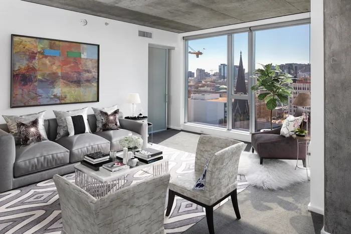 A sleek, monochromatic furnished living room in a Portland Oregon apartment overlooking downtown.