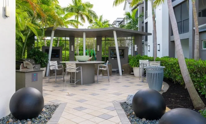 Outdoor lounge at our apartments for rent in Delray Beach, featuring outdoor seating and a grill station.