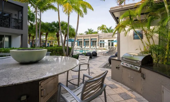 Outdoor kitchen and grill next to a resort-style pool by the Franklin Delray apartments near Boca Raton.