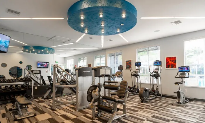 Various exercise machines inside a Delray Beach apartment gym.