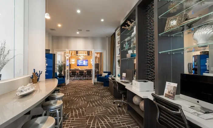 Office and co working space at our apartments in Delray Beach, featuring long desks with computers on them.