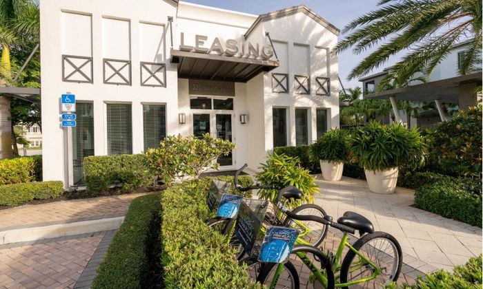 Photograph of the grounds at our apartments, featuring two bikes leaning up against a shrub. The bikes say "Franklin Delray"