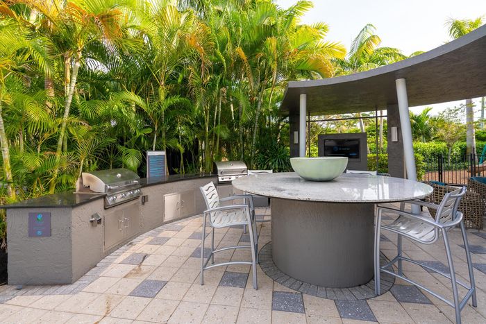 Outdoor lounge at our apartments for rent in Delray Beach, featuring outdoor seating and a grill station.
