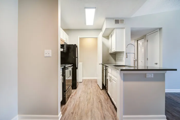 Model kitchen at our apartments in Bellevue, featuring wood grain floor paneling and stainless steel appliances.Model kitchen at our pet-friendly apartments in Nashville, featuring wood grain floor paneling and stainless steel appliances.