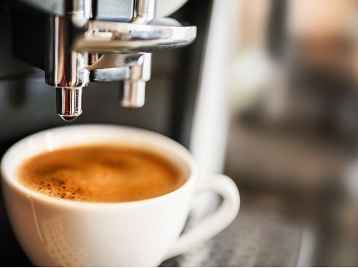 A shot of espresso being pulled at a cafe near our apartments for rent in Marlborough, featuring a small white mug.