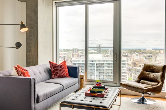 Model living room at our apartments in Portland, OR, featuring a leather chair, colorful decor, and a flat screen TV.