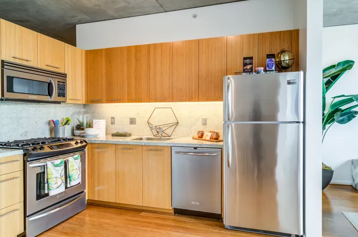 Close up view of a kitchen with light wooden cabinetry and granite countertops inside an apartment in downtown Portland.