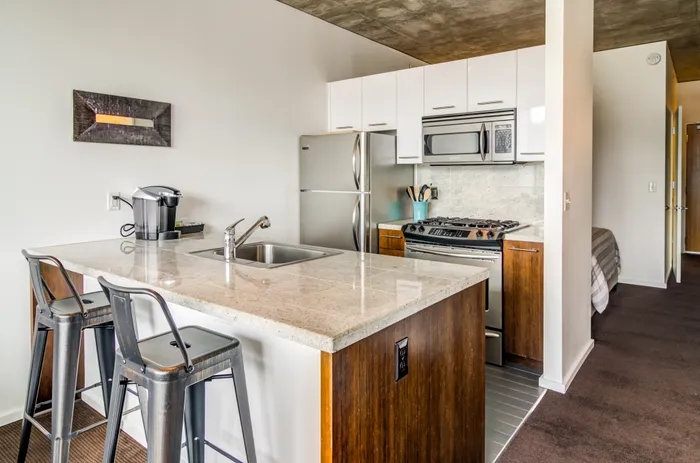 A luxury Portland Oregon apartment kitchen with a kitchen island and granite countertops.