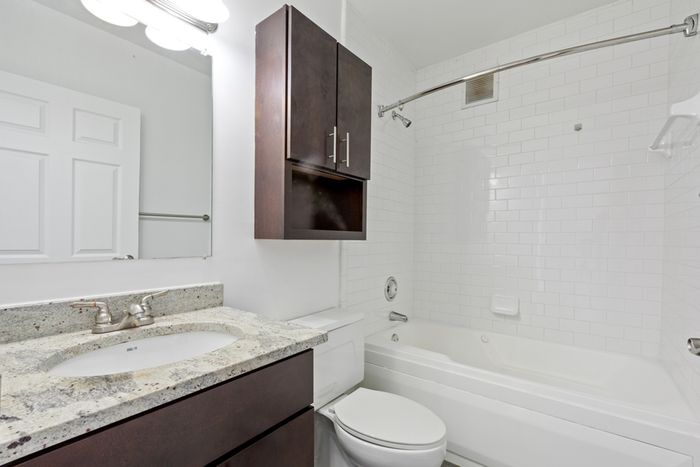 Bathroom with granite countertop and storage