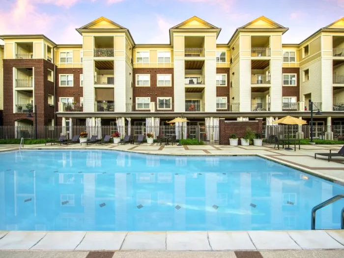 The pool area at our apartments for rent in Alexandria, featuring beach chairs and a view of the apartment complex.