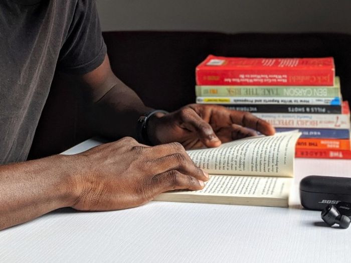 Someone reading a book near our apartments for rent in Washington DC, featuring a stack of books in the background.