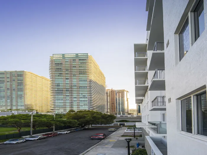 The street in front of our Brickell apartments for rent in Miami, featuring a view of parked cars and high rise buildings.