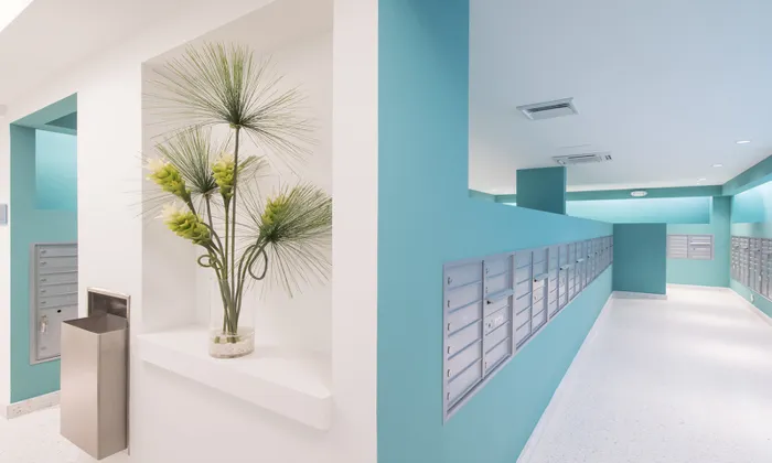 Mail room at our apartments in Brickell, featuring locking mail boxes and a vase with flowers in it.
