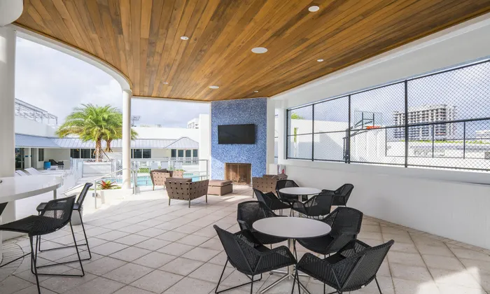 An outdoor patio with seating and television outside downtown Miami Apartments.