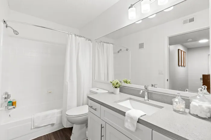 Model bathroom at our apartments in Clearwater, featuring grey countertops and a shower bath combo.