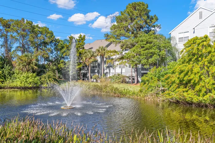 Exterior view of Clearwater apartments for rent with water fountain and lush landscaping.