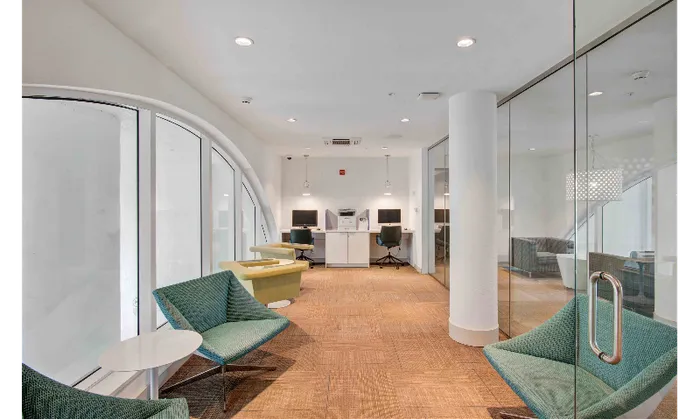 Small lounge area with blue seating inside SOMA at Brickell apartments.