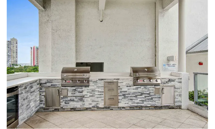 Grill station at our apartments for rent in Brickell, featuring two gas grill with stone masonry bases.