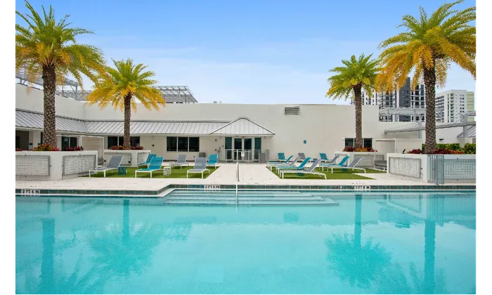 The pool deck at our apartments for rent in Brickell, featuring astroturf, beach chairs, and a clubhouse.