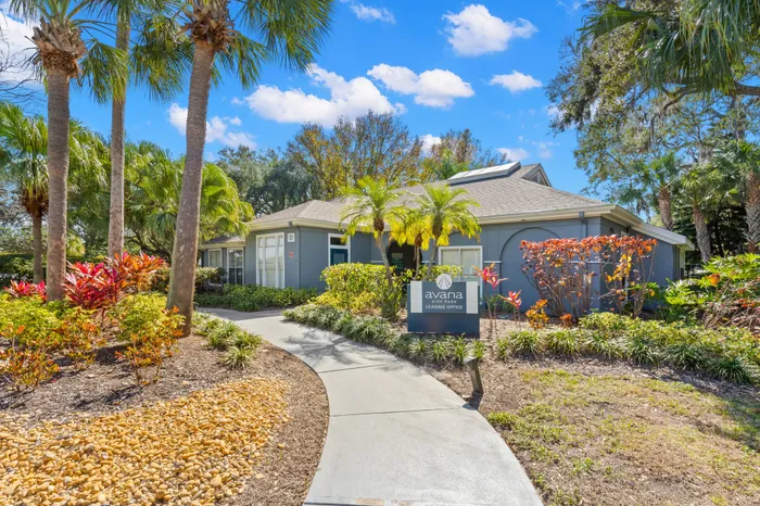 The exterior of the leasing office at our apartments for rent in Atlanta, featuring palms and bushes.