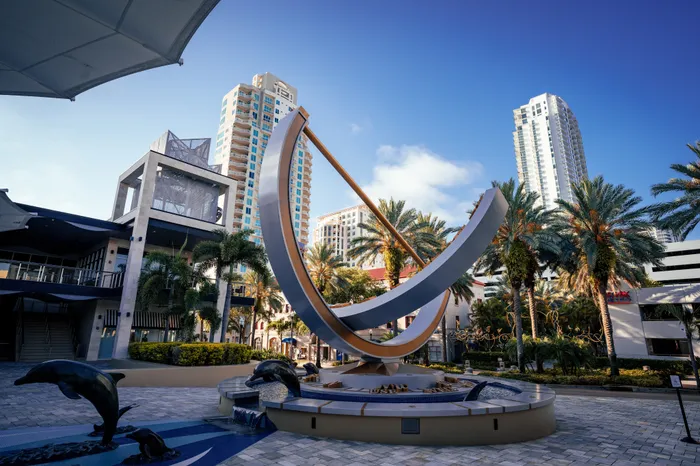 Public sculpture near our apartments for rent in Clearwater, FL, featuring dolphins and a view of skyscrapers.
