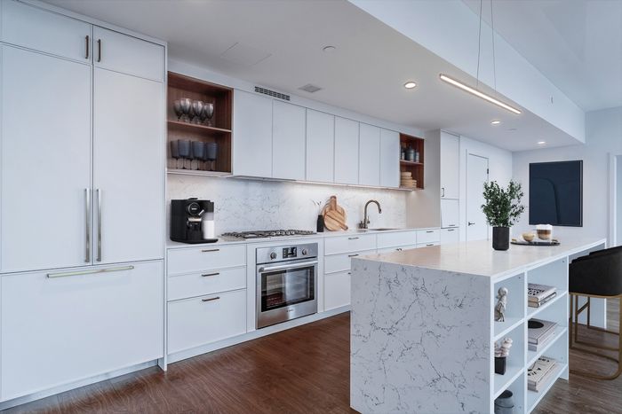 Penthouse kitchen with stylish cabinetry and backsplash, large island and plenty of counter space.