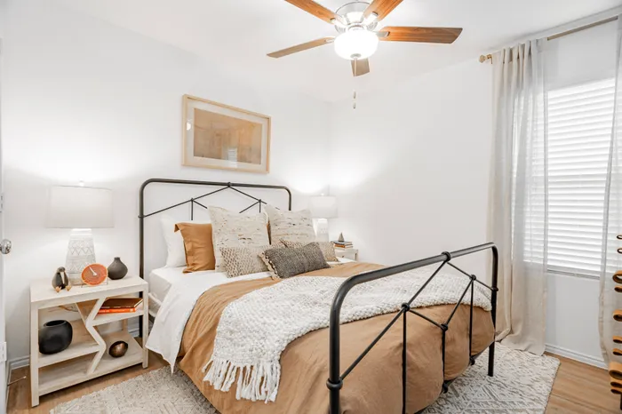 iron bed frame with tan and white bedding