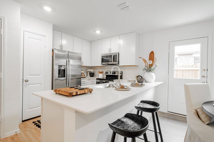 kitchen island with white cabinets and stainless steel appliances