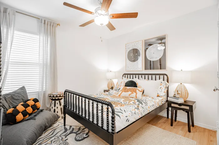 iron bedframe in bedroom with white and tan bedding