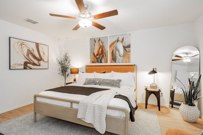 primary bedroom with horse portrait above bed and orange headboard