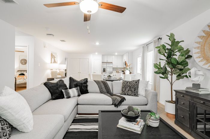 living room with grey sectional and black coffee table and accents