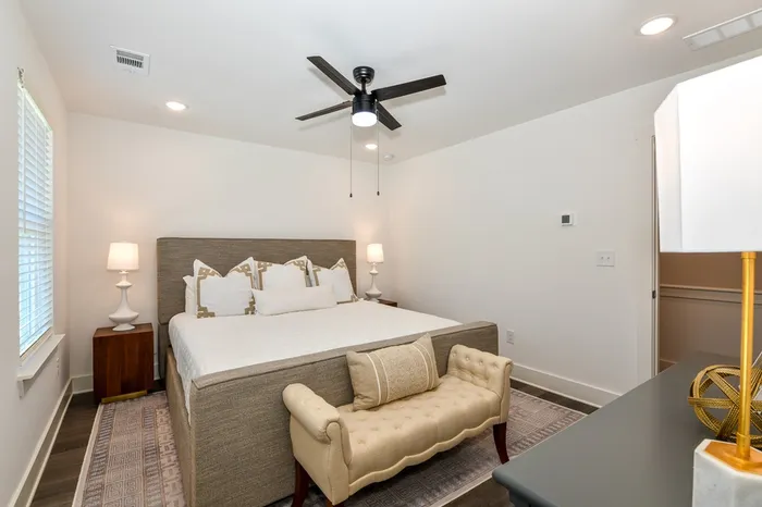 bedroom with beige headboard and plain bedding