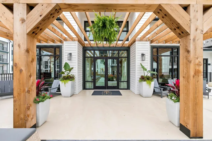 Apartment clubhouse entrance with glass doors and landscaping