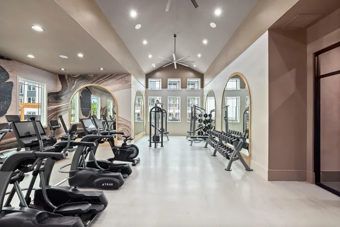 Fitness center with cardio machines and strength equipment at Asher apartments