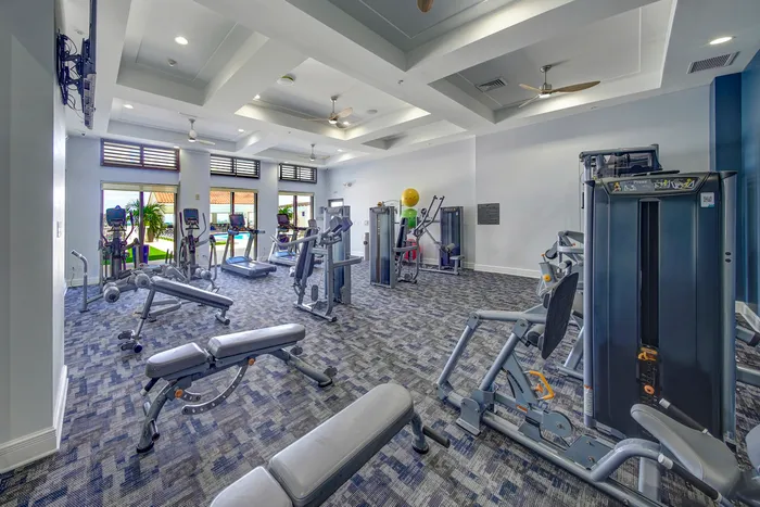 The gym at our apartments for rent in Boca Raton, FL, featuring treadmills and weight lifting machines.