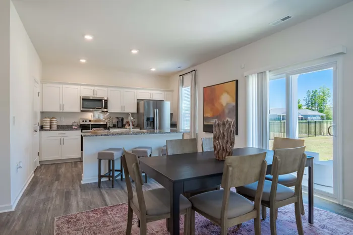 dining room table looking into kitchen with white cabinets