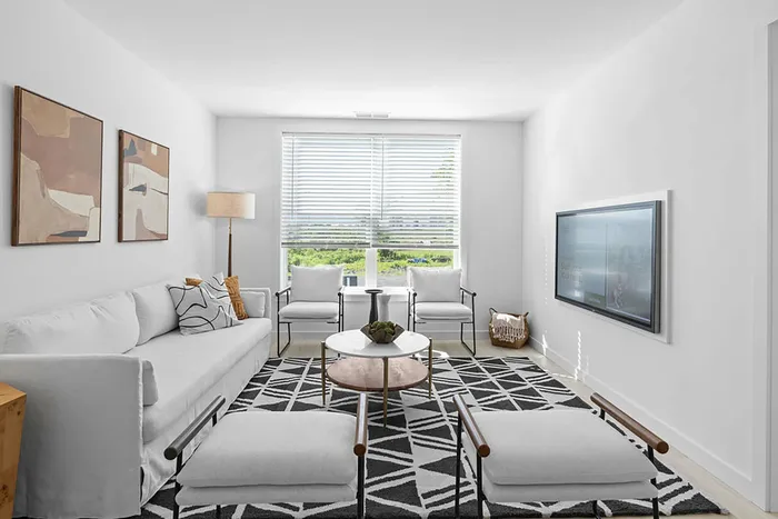 Living area with seating, art, TV, and coffee table.
