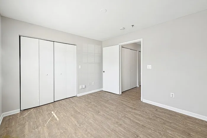 Bedroom with large closet and hardwood style flooring