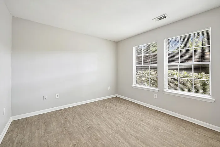Spacious bright bedroom wiht hardwood style flooring