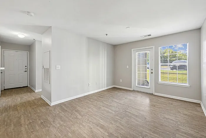 Spacious bright living room with hardwood style flooring.