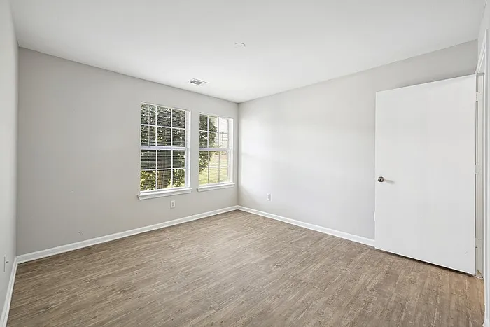 Spacious bedroom with hardwood style flooring