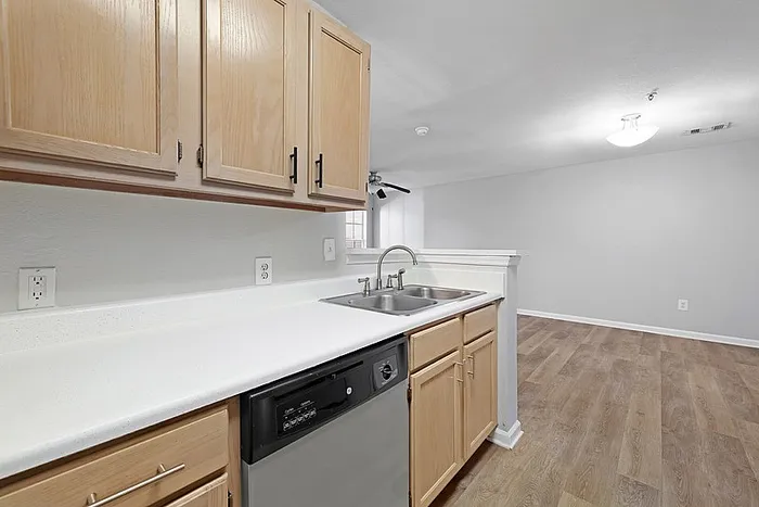 Kitchen with upgraded finishes and plenty of counterspace, looking into dining area with hardwood style flooring.