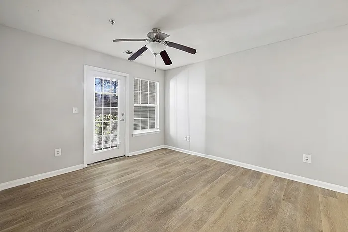 Spacious Living room with hardwood style flooring and a ceiling fan.